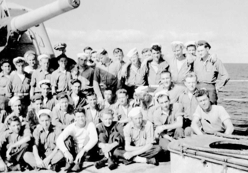 First Division:<br>Front Row (L&rarr;R) C. Angevine, [unknown], D. Virgillio, [unknown], [unknown].<br>Middle Row: E. Woodbury, [unknown], [unknown], [unknown], [unknown], [unknown], [unknown], J. Teague, [unknown], D. Weiler, [unknown].<br>Standing: J. Beard, [unknown], [unknown], [unknown], [unknown], [unknown officer], [unknown], [unknown], [unknown], J. Ouwelant (looking down), [unknown], K. Moore, [unknown], D. Freudeman, W. Curry, [unknown], R. Hamby.